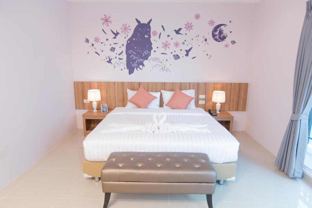 曼谷The Bedroom Ladprao 101 Bangkok - SHA的卧室配有一张鲜花床,墙上挂着一只猫