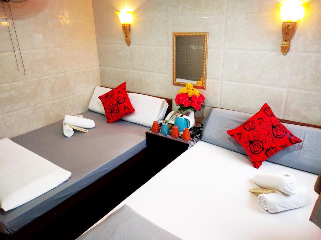 香港Days Hostel Block D的宿舍间内的两张床,配有红色枕头