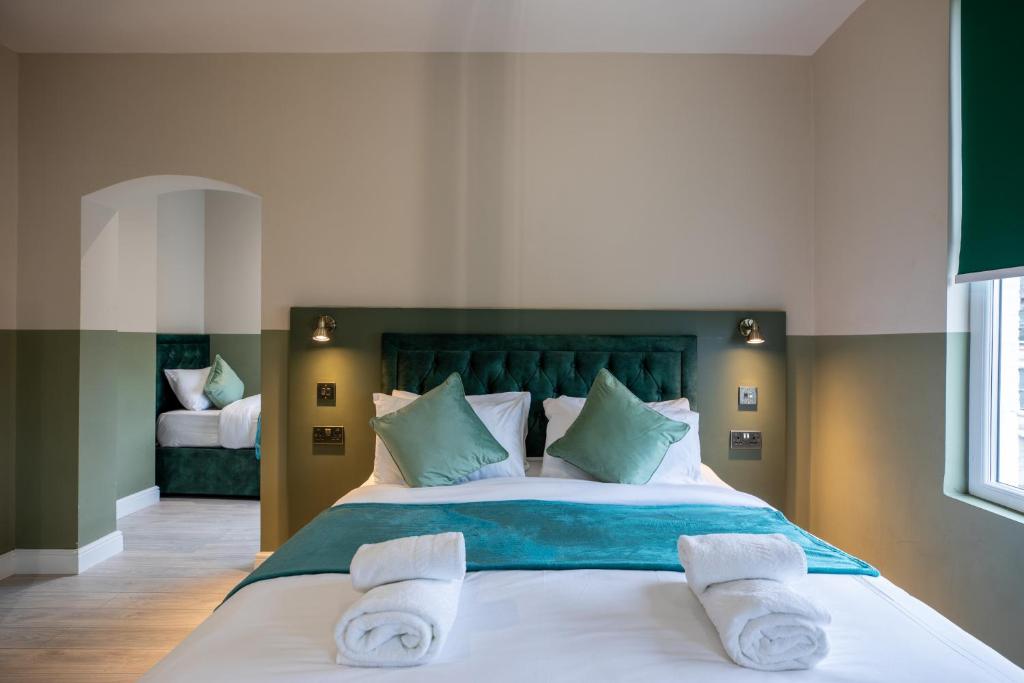 伦敦The Chapter Hotels - Finsbury Park的一间卧室，有一张大床，床上有毛巾