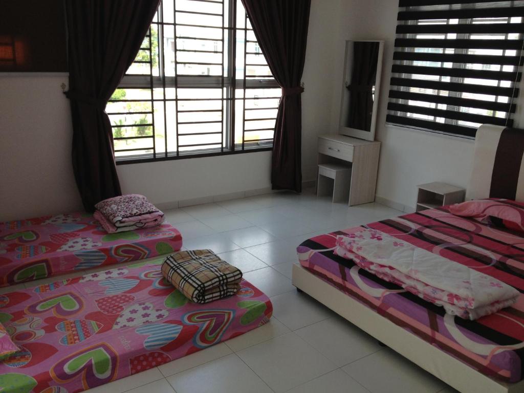 新山舒适度假屋@武吉英达的一间卧室配有两张床和电视。