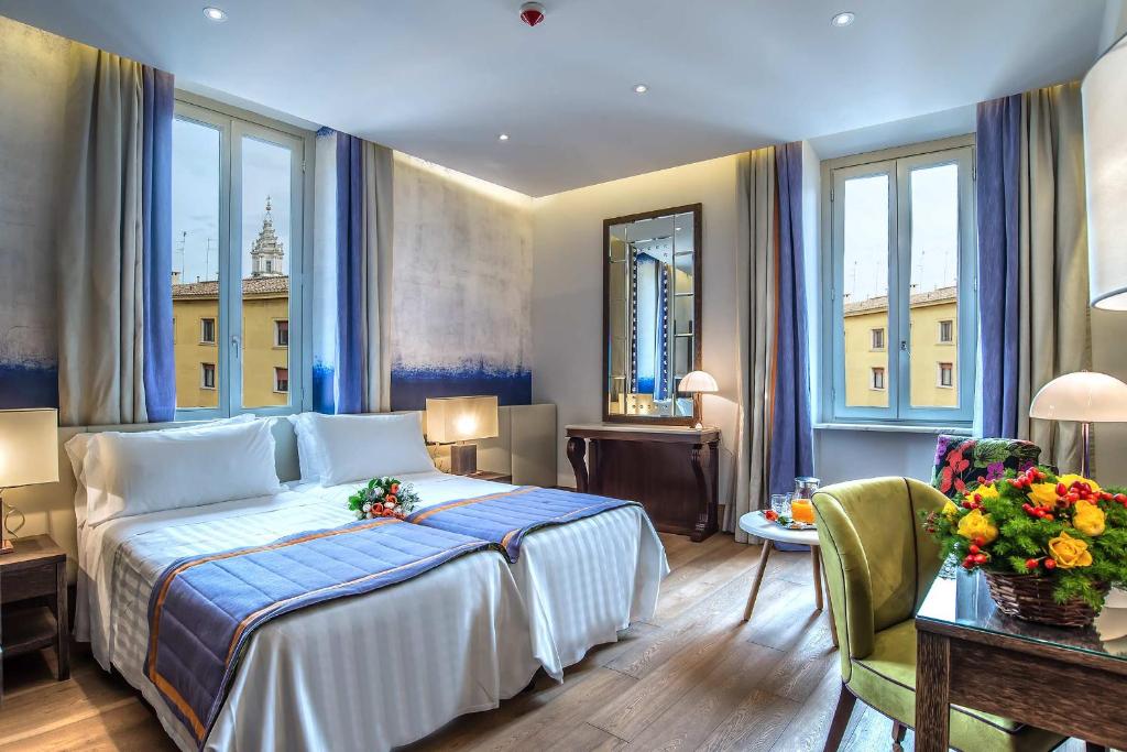罗马马尔蒂斯宫殿酒店的酒店客房带一张床、一张桌子和椅子