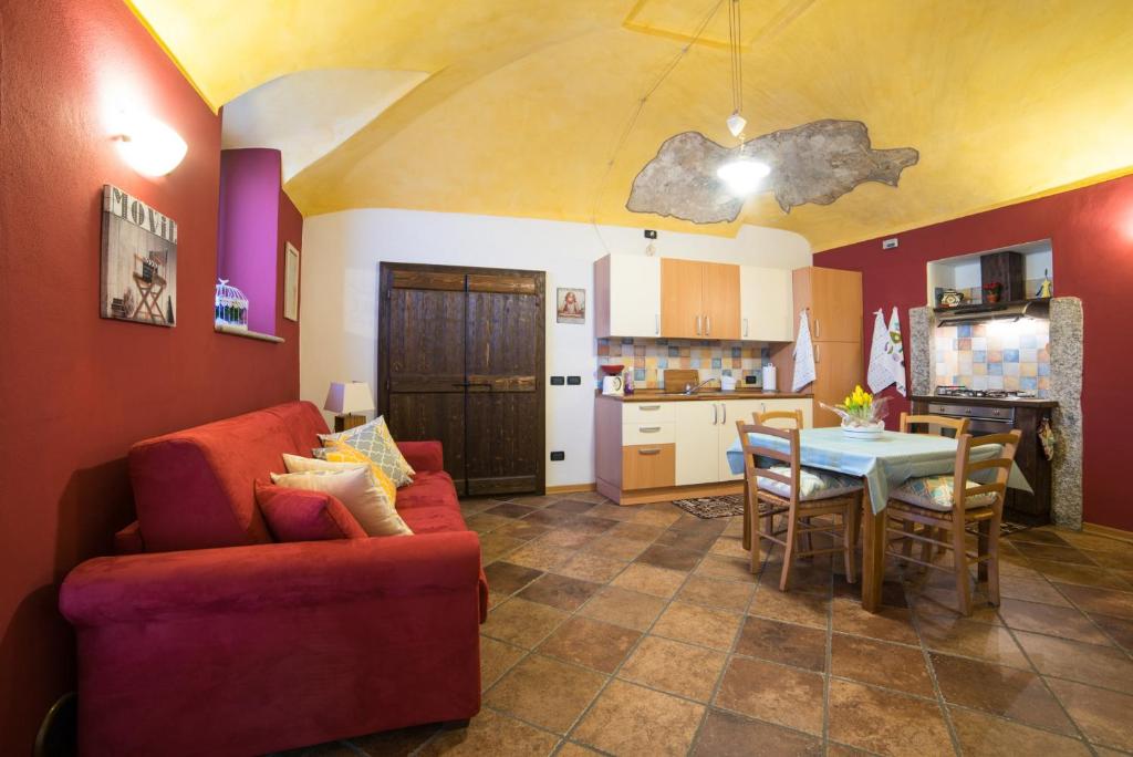 阿罗纳Casa Corte Alla Rocca的客厅配有红色的沙发和桌子