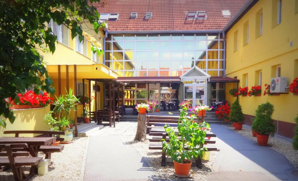 埃格尔博塔克斯汽车旅馆的一座带木凳和鲜花的建筑的庭院