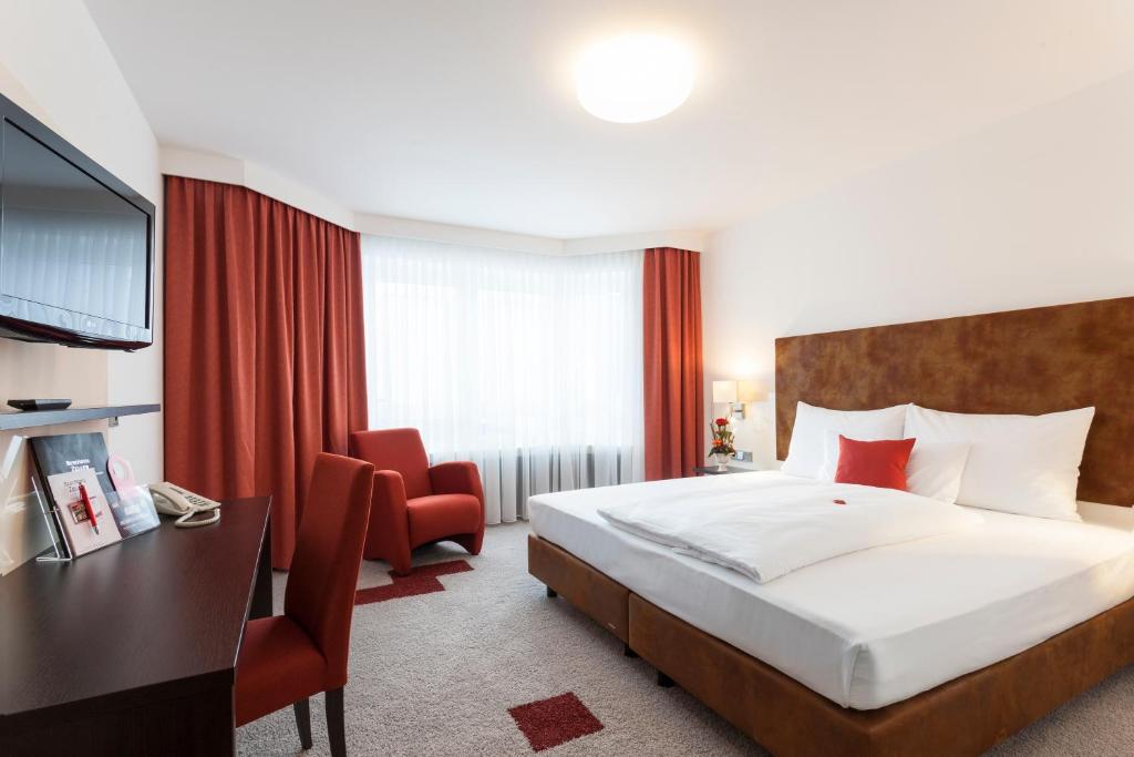 柯尼希斯布伦佐拉贝斯特酒店的酒店客房带一张大床和一把椅子