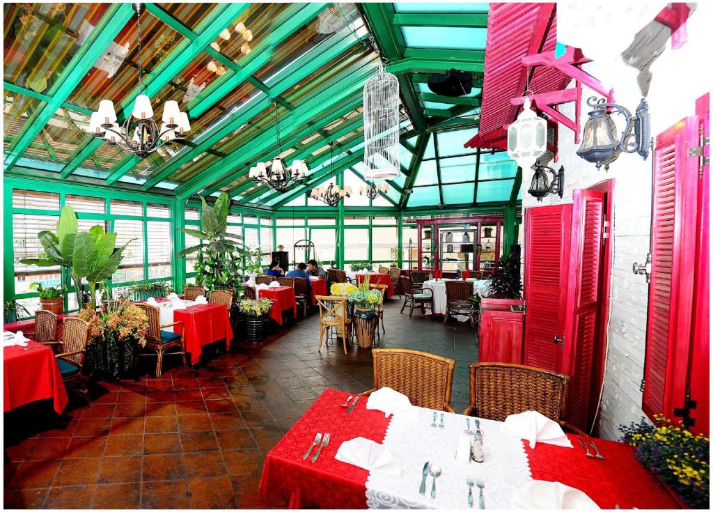 乌兰巴托纳兰图尔酒店的餐厅设有桌椅和红白桌子