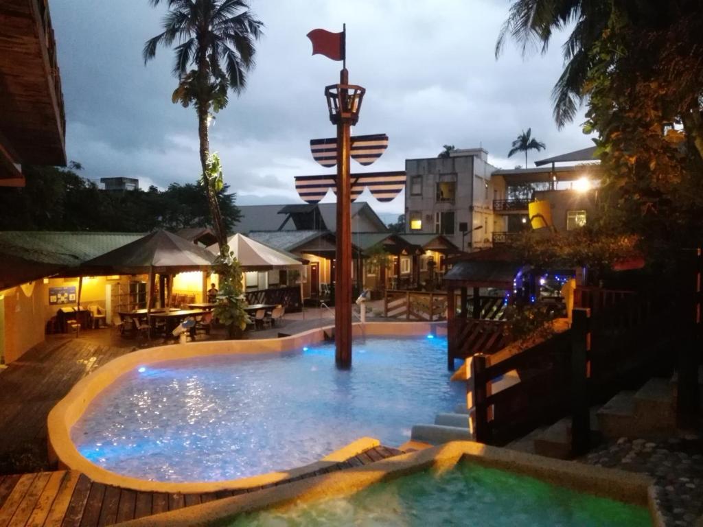 瑞穗乡椰子林温泉饭店的游泳池在晚上,中间挂着旗帜