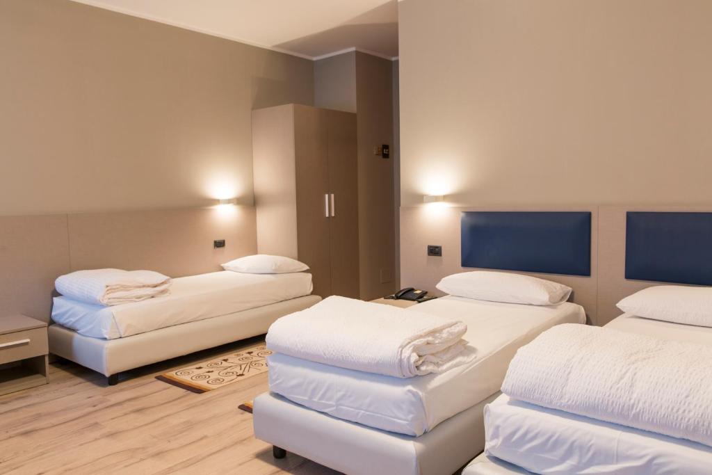 马尼亚戈艾尔伯格蒙特内格罗酒店的一间设有两张带白色床单的床的房间