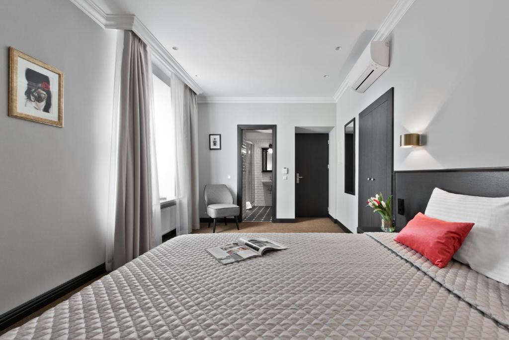 维尔纽斯第15大道酒店的一间卧室配有一张带红色枕头的大床