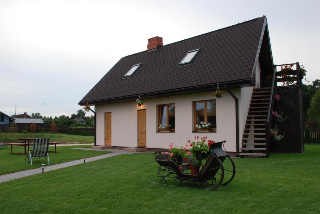 普里恩斯慕斯Brīvdienu Māja Riekstnieki的一间黑色屋顶的白色小房子