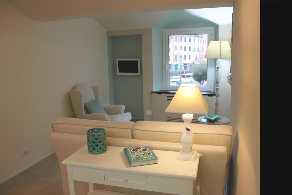 波托菲诺Clara's House的客厅配有沙发和带台灯的桌子