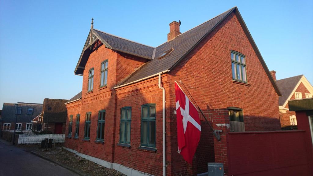 凡岛Fanø Bed & Boats的红砖建筑,上面有旗帜