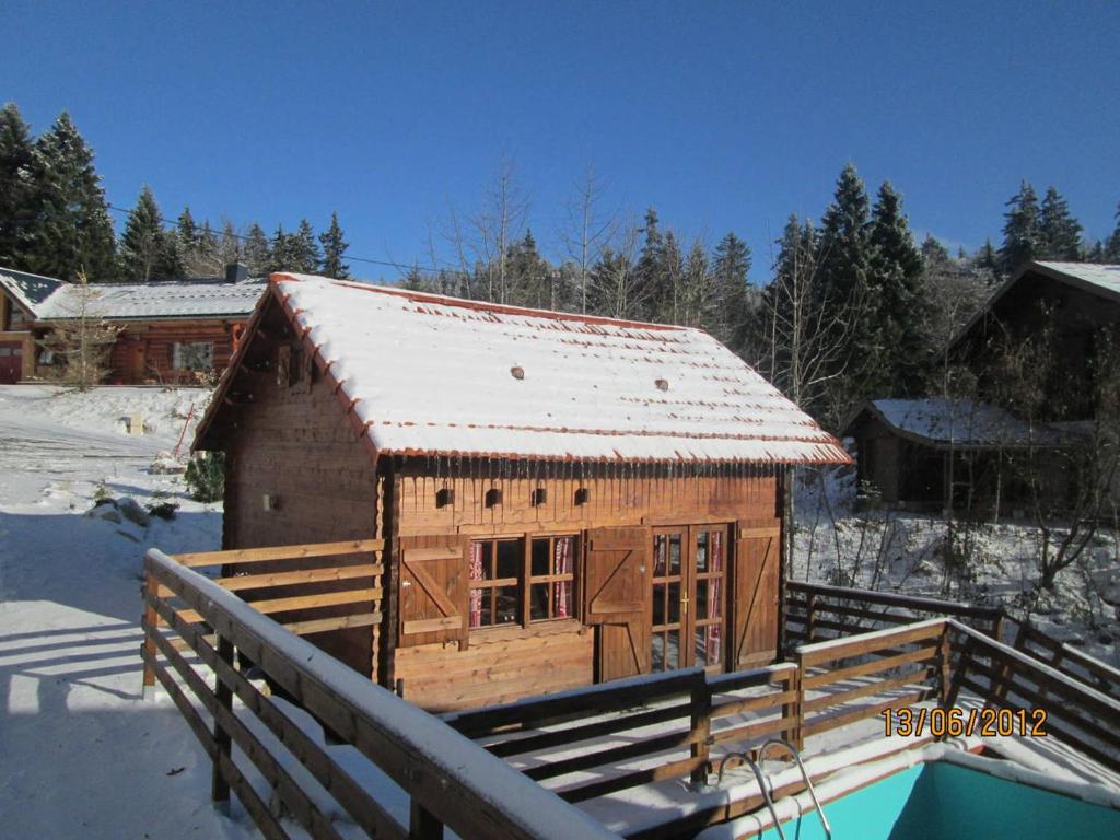 米茹蒙茨朱拉木屋的一座带雪盖屋顶的小木结构建筑