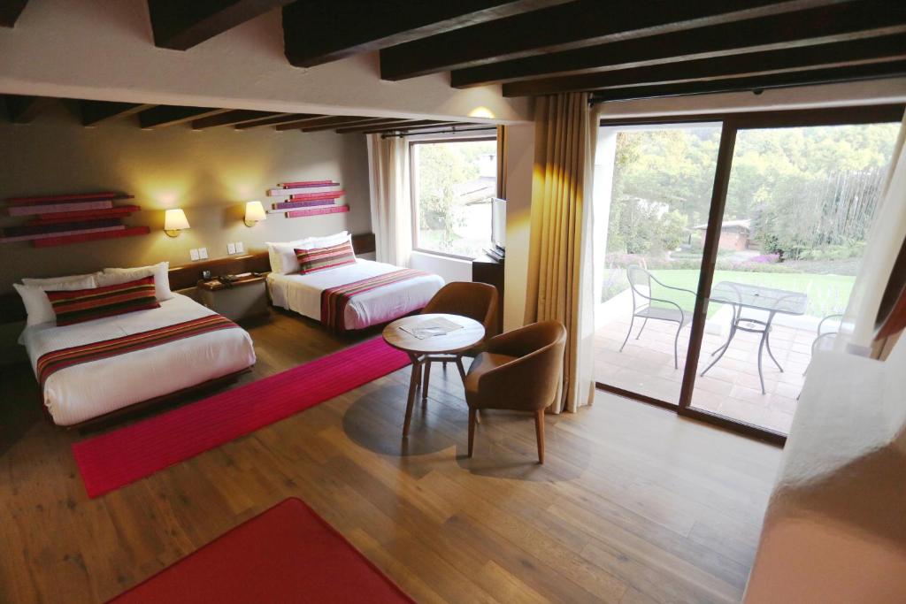 巴耶德布拉沃阿瓦达罗高尔夫及Spa度假酒店的一间带两张床的卧室和一间带庭院的客厅
