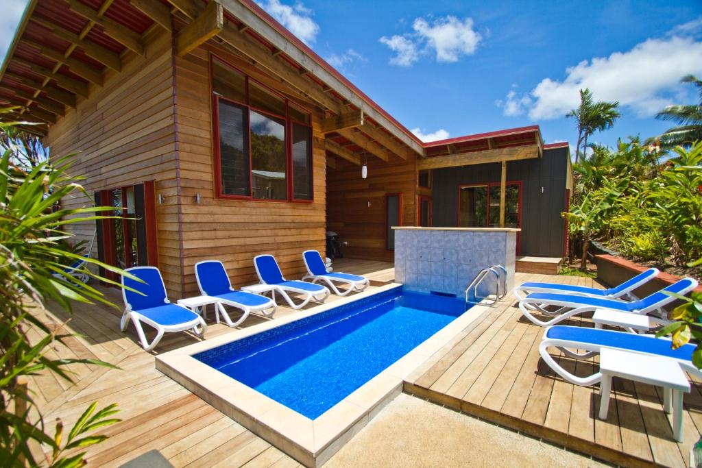 拉罗汤加拉罗汤加天堂假日别墅的一座房子,四周设有游泳池和椅子