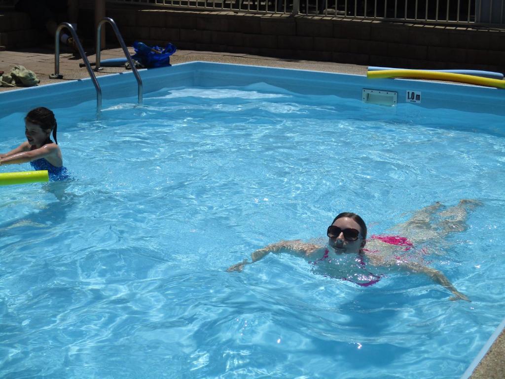 梅林布拉安考贝尔假日公寓的游泳池里的女人和孩子