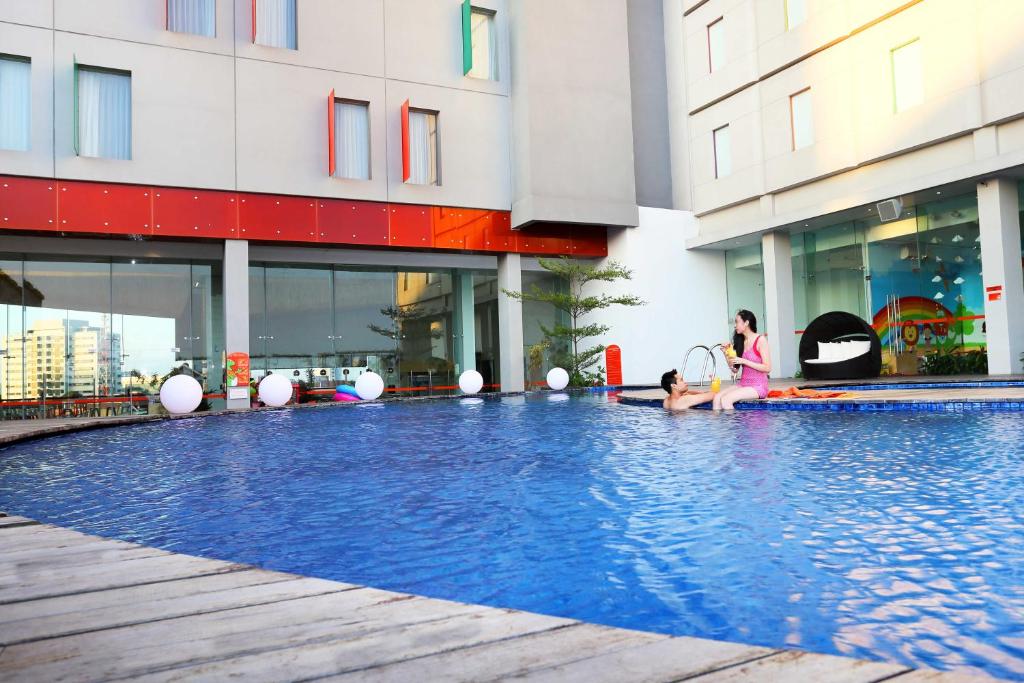 泗水POP！古本酒店的坐在建筑物游泳池里的女人