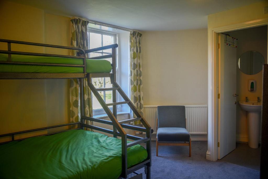 英格尔顿Ingleton Hostel的一间卧室配有两张双层床和椅子