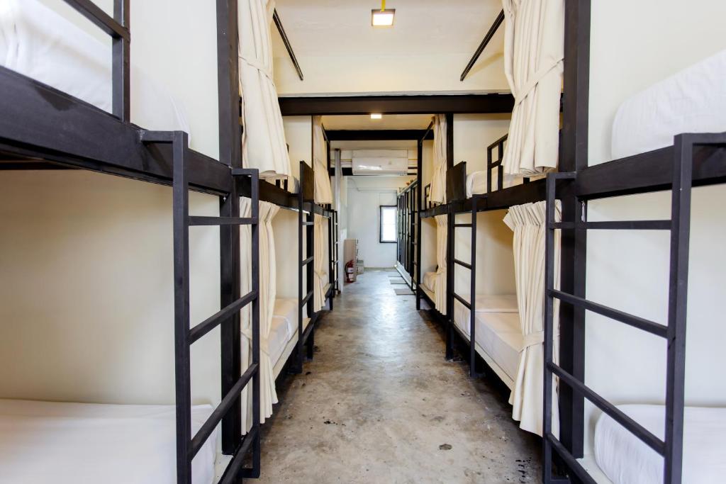 乔木提恩海滩Nomad Plus Life Hostel Pattaya的宿舍间的走廊,配有双层床