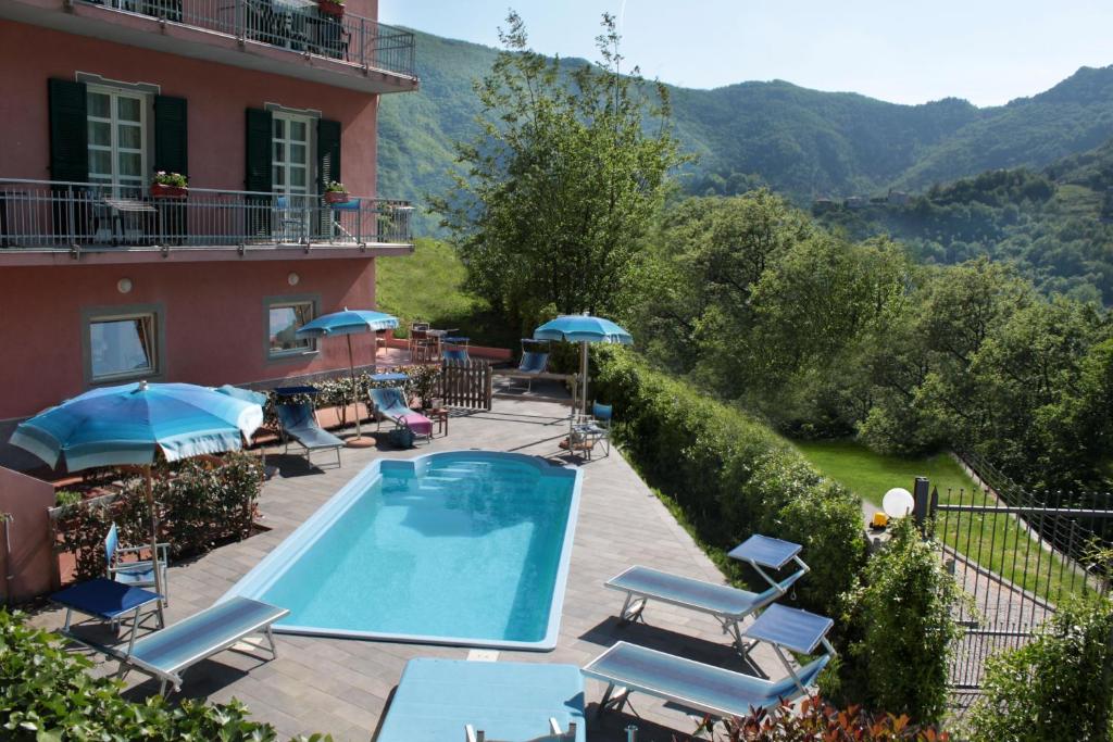 Balestrino卡德伯纳酒店的酒店设有带椅子和遮阳伞的游泳池