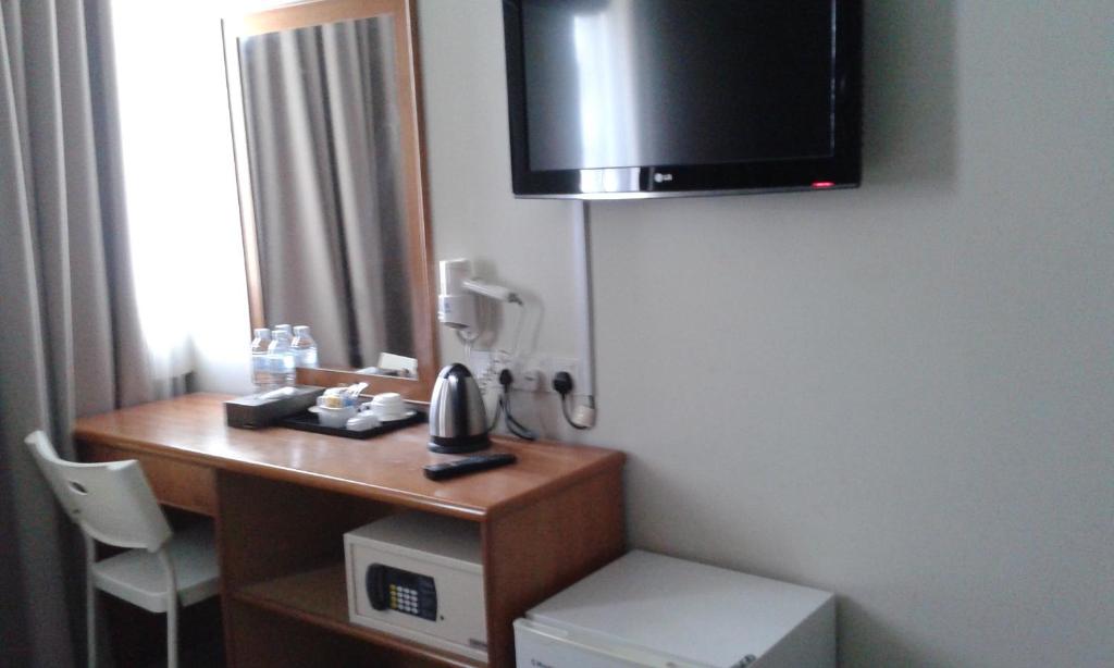 关丹斯普林酒店的客房设有带电话和电视的书桌。