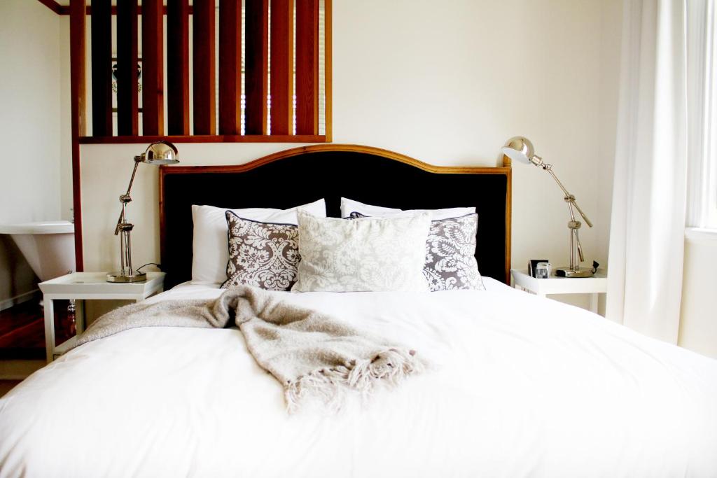 新普利茅斯霍斯金别墅的卧室配有白色的床单和枕头