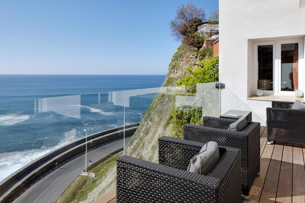 吉塔里亚赛亚兹盖塔利亚酒店的阳台配有椅子,享有海景。