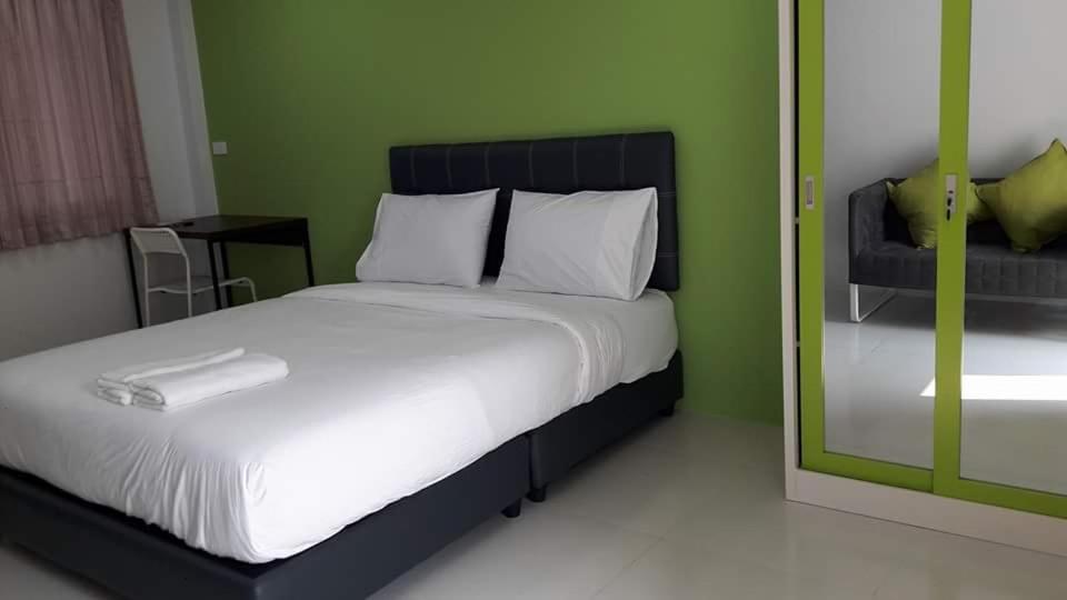 南邦南邦三叶草旅馆的一间卧室设有一张床和绿色的墙壁