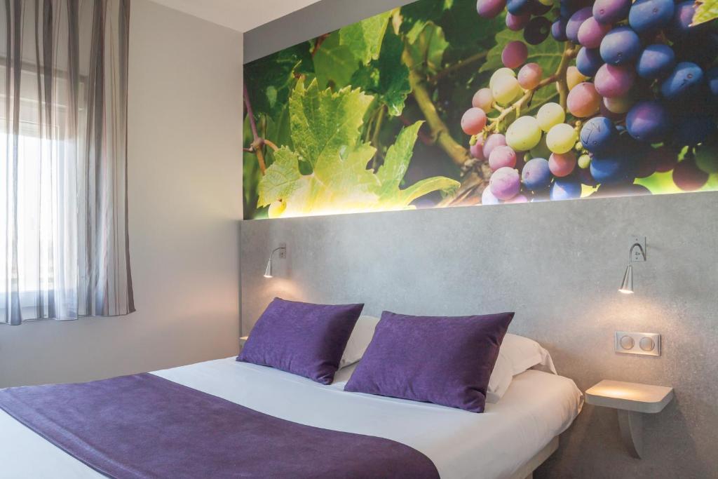 舍诺夫LOGIS Hotel l'Escargotière Dijon Sud - Chenove的一间卧室配有一张带紫色枕头的床和一幅画