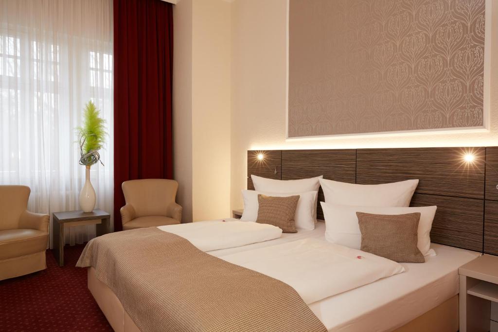 纽伦堡普林斯利津特酒店的酒店客房带一张大床和一把椅子
