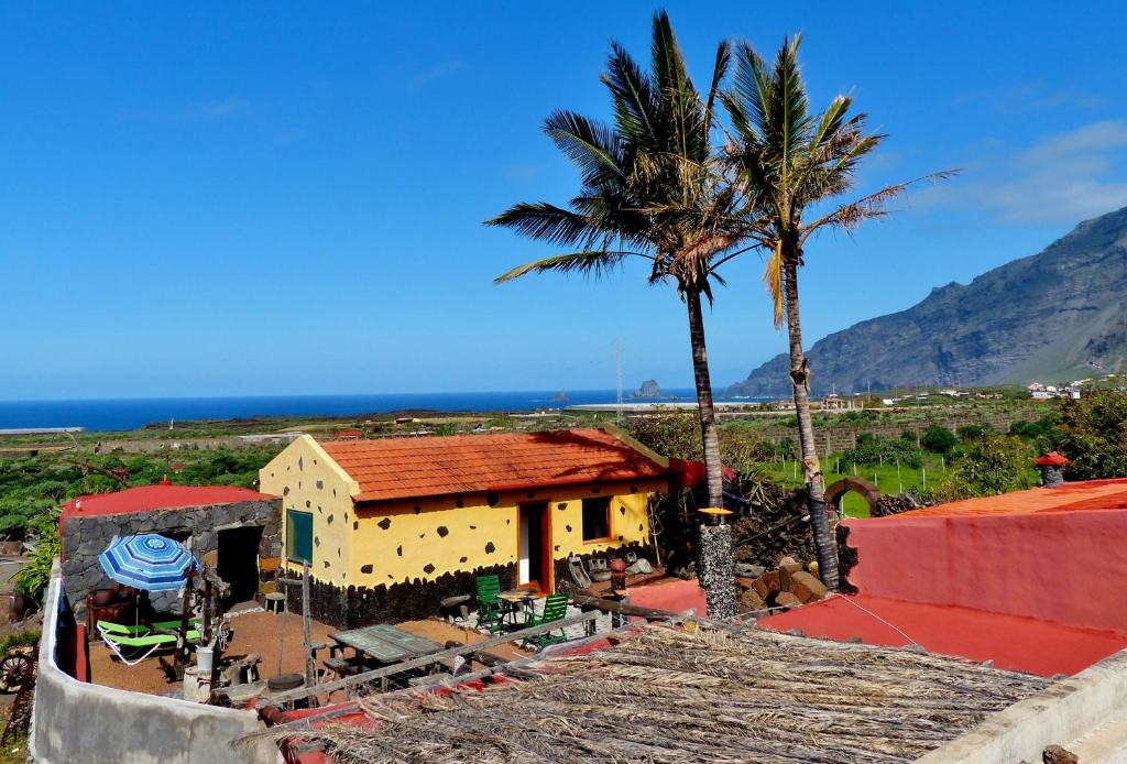 弗龙特拉Casa Guinea的棕榈树和海洋的黄色房子