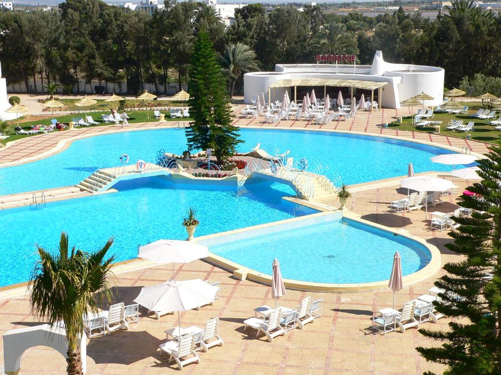 莫纳斯提尔自由度假酒店的一个带椅子和遮阳伞的大型游泳池