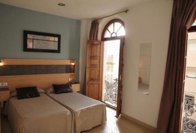 休达鲁伊兹广场旅馆的一间卧室设有两张床和窗户。