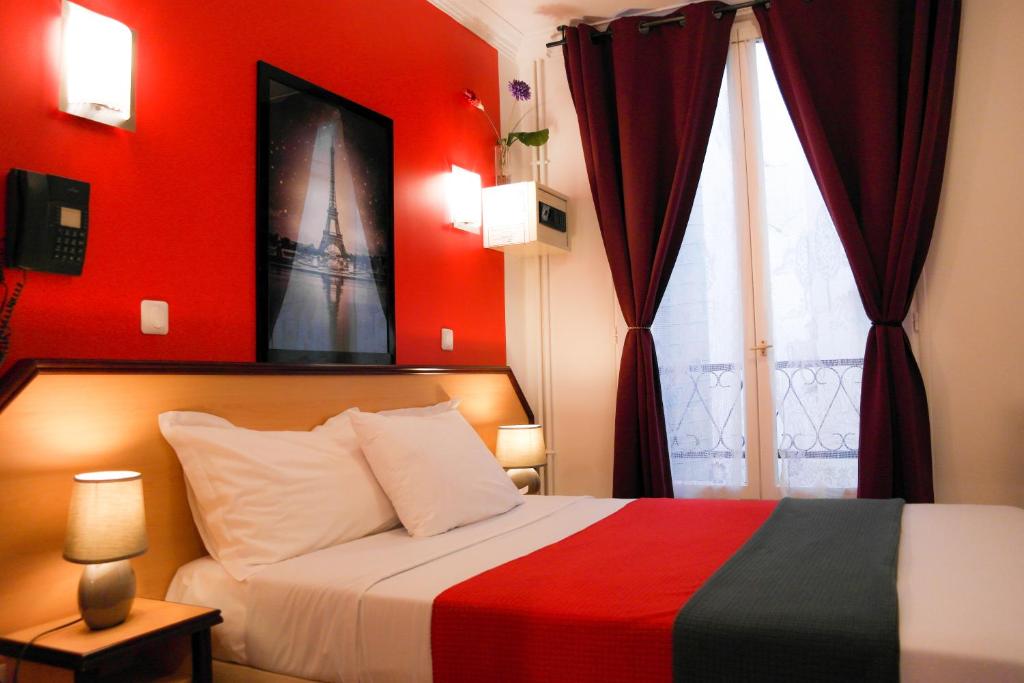 巴黎奥德兰酒店的一间卧室设有一张红色墙壁和窗户的床