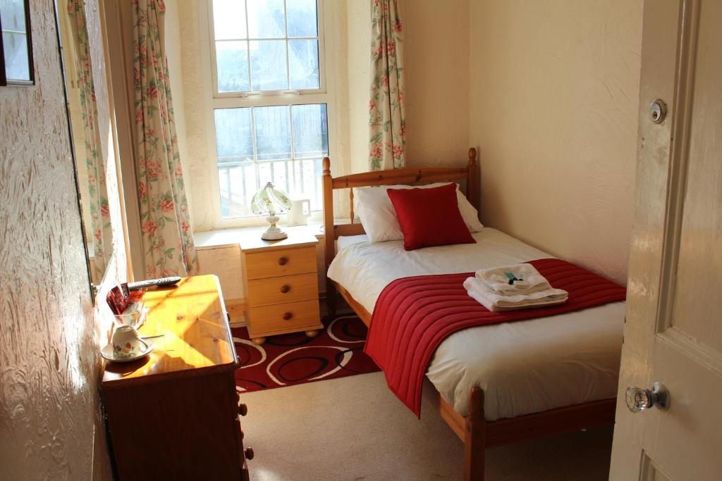 彭布罗克中门酒店的一间卧室设有两张床、一张桌子和一个窗口。