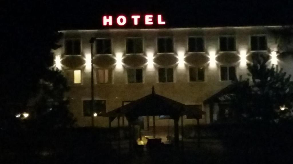 弗沃茨瓦韦克Hotel Gościniec的夜间的酒店,酒店标志