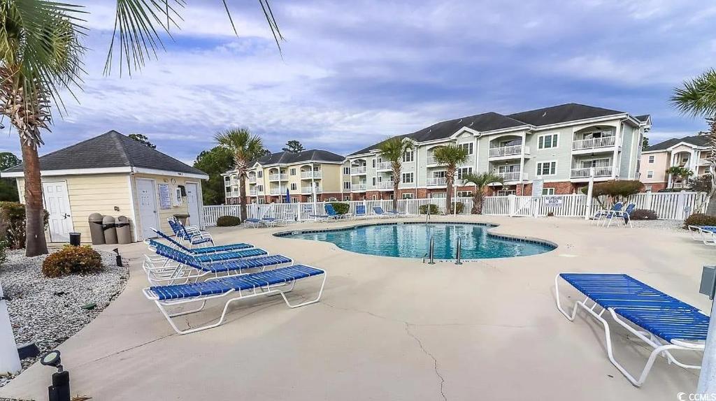 默特尔比奇Beautiful 1500 s f 3 Bd - 2 Ba condo overlooking stream and golf course的度假村内带躺椅的游泳池