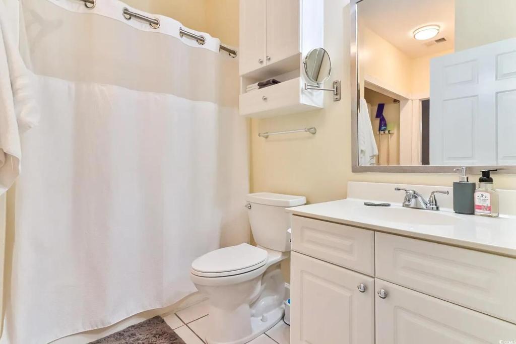 默特尔比奇Beautiful 1500 s f 3 Bd - 2 Ba condo overlooking stream and golf course的配有马桶、水槽和镜子的浴室