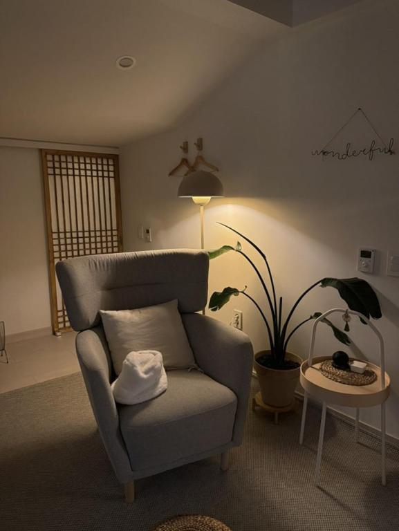 江陵市Bow Hanok House的一间带椅子和植物的客厅