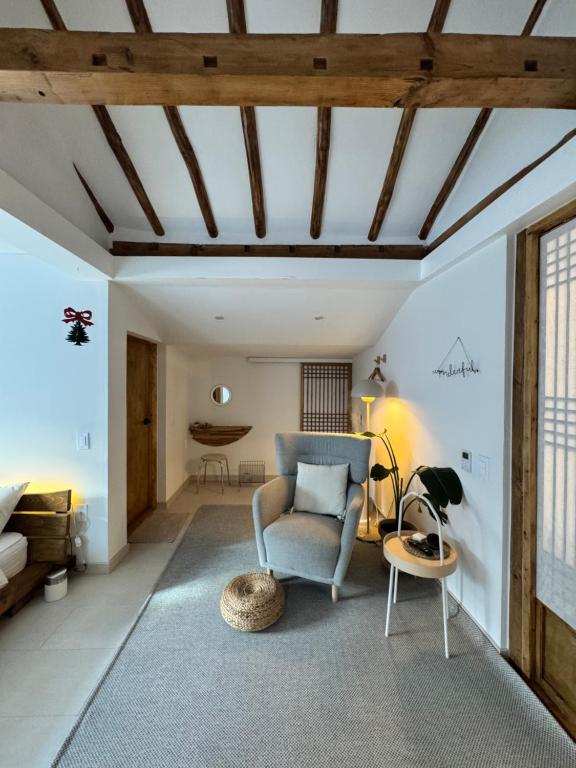 江陵市Bow Hanok House的客厅里有一把蓝色的椅子和一张桌子