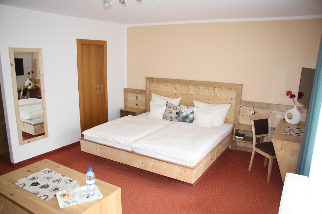 福森希尔霍夫兰德宫酒店的一间卧室配有一张床、一张桌子和一面镜子