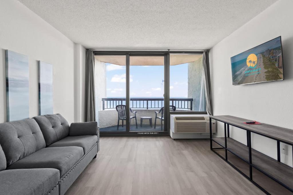 默特尔比奇Compass Cove 759 - Oceanfront的带沙发和桌子的客厅