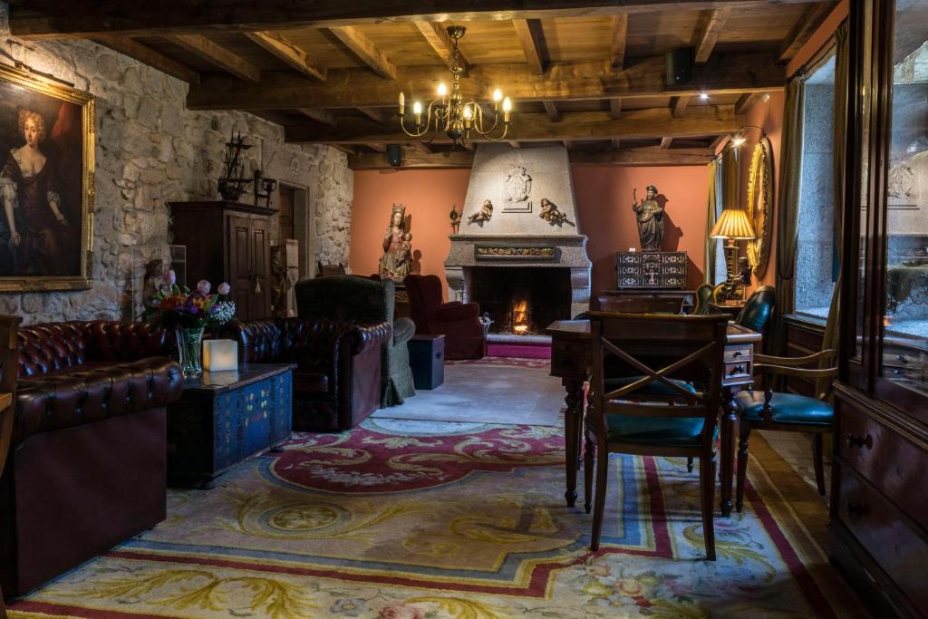 阿瓜尔达圣贝尼托修道院酒店的客厅设有壁炉、桌子和椅子