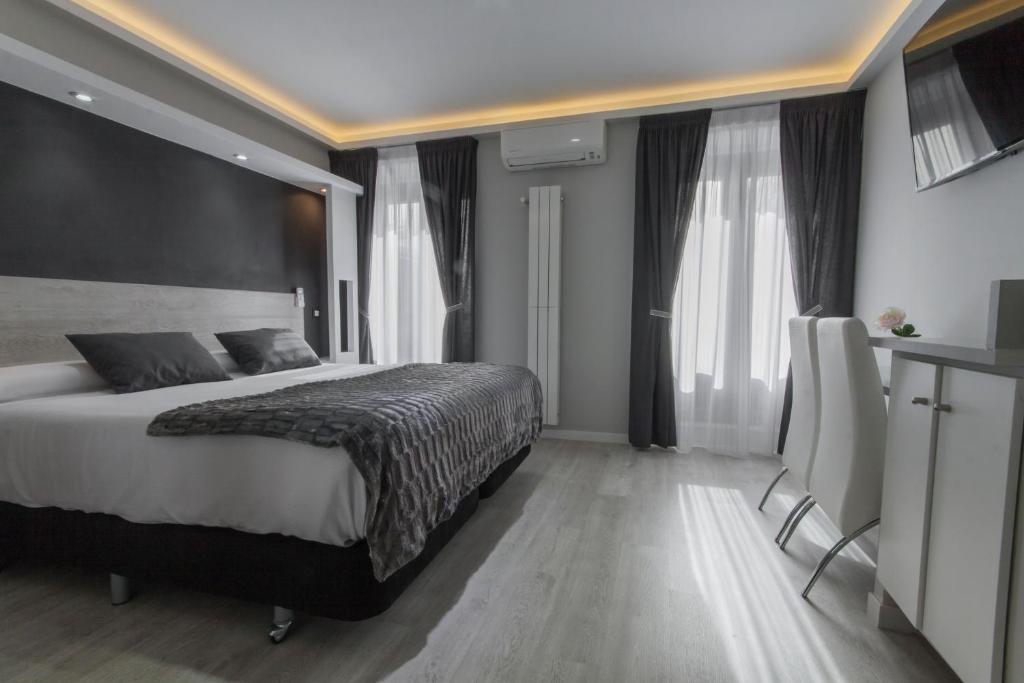 马德里马德里奥威奈特旅馆的一间卧室设有一张大床,部分设有窗户。