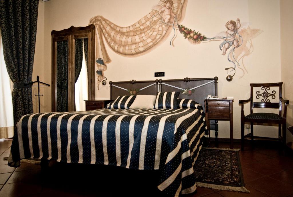 皮内罗洛雷吉纳酒店的一间卧室配有一张带黑白条纹毯子的床