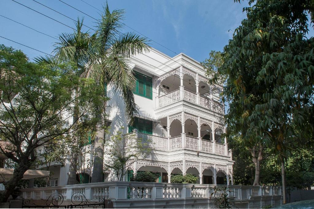 新德里33号别墅住宿加早餐旅馆的一座白色的建筑,前面有棕榈树