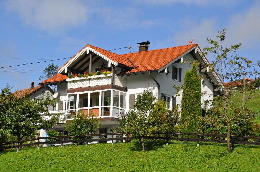 韦尔塔赫Ferienwohnung Unglert的山坡上一座白色房子,屋顶橙色
