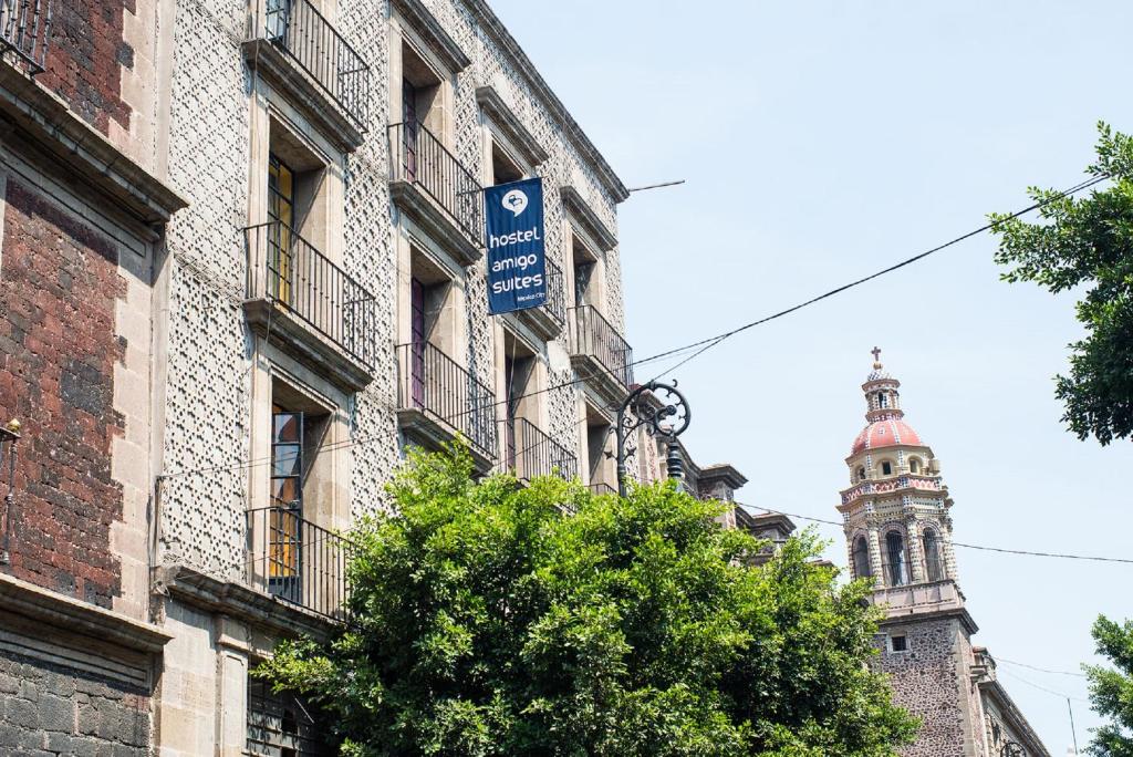 墨西哥城Hotel Amigo Suites的钟楼建筑上的标志