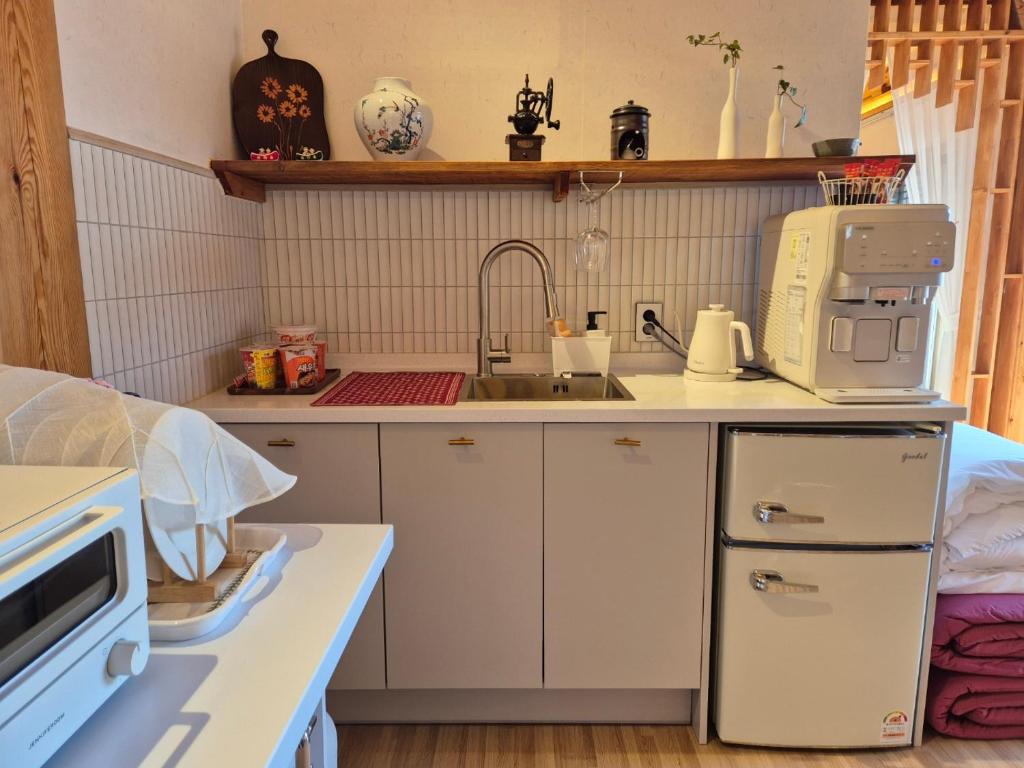 庆州Hanok Stay Seowa的带水槽和微波炉的小厨房