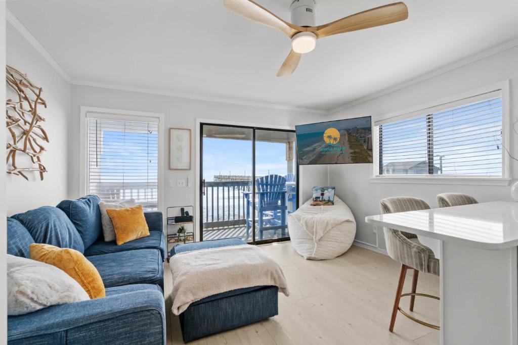 默特尔比奇Sea Cabin 118 - Oceanfront的客厅里有一张蓝色的沙发和一张桌子