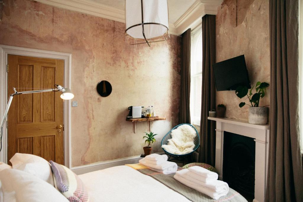 伦敦库尔佩珀酒店的一间卧室配有一张床和一个壁炉
